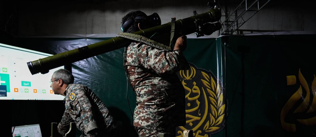Un membro dell'esercito iraniano mostra il funzionamento di un'arma portatile con l'ausilio di un simulatore  (APN)