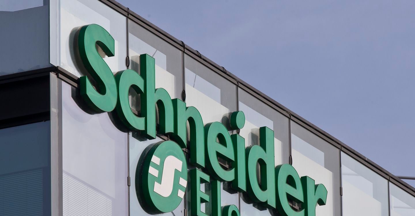 Green Schneider Electric logo on the glass facade of a company building