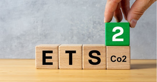 ETS 2 European Trading System. Business-environmental concept. ETS written on wooden blocks and a businessman's hand adding a cube with the number two. New System for Trading in Carbon Emission Permits. Growing Cost of Fossil Fuels. Closeup. Copy space. Rochu_2008 - stock.adobe.com