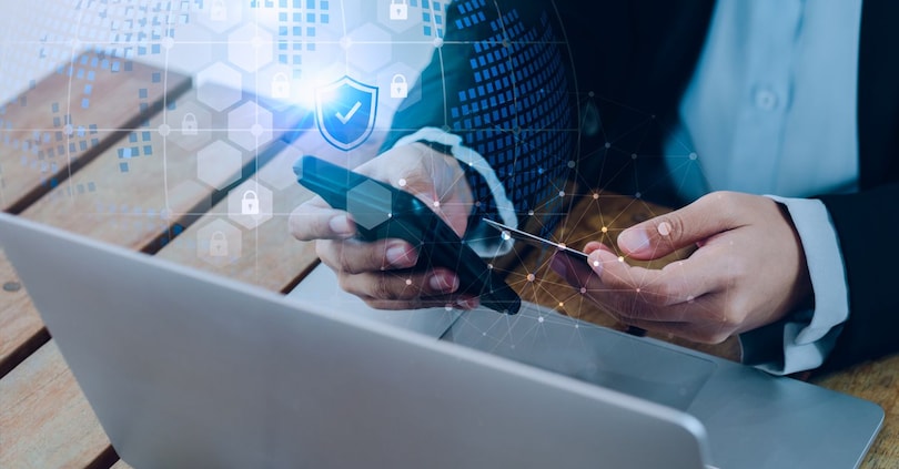 Secure payment concept. Security shield icon and lock symbol hologram appear while business people use mobile smart phone purchase with credit card in hand for online shopping and banking transaction. tete_escape - stock.adobe.com