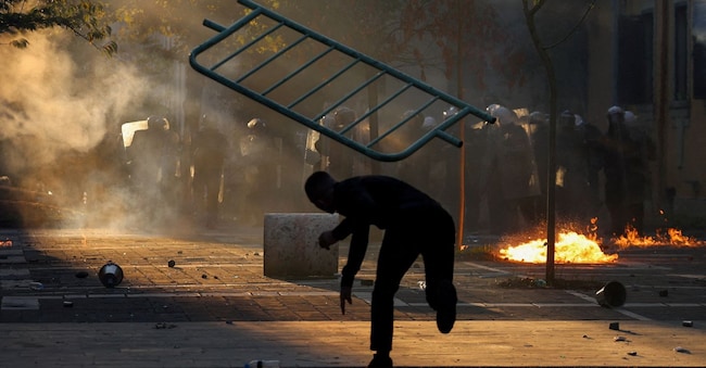 Un manifestante lancia una barricata durante una manifestazione studentesca antigovernativa a Tirana, in Albania, il 18 ottobre 2026. REUTERS/Louisa Gouliamaki     IMMAGINI DEL GIORNO DI TPX REUTERS