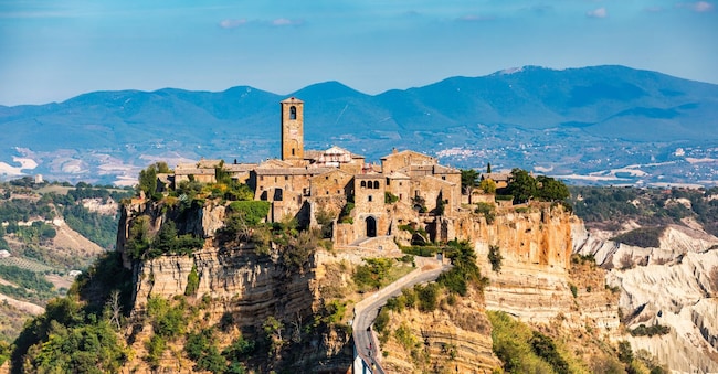 The famous Civita di Bagnoregio on a sunny day. Province of Viterbo, Lazio, Italy. Medieval town on the mountain, Civita di Bagnoregio, popular touristic stop at Tuscany, Italy. Shutterstock