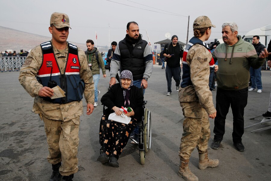 Migranti siriani arrivano al valico di frontiera di Cilvegozu per attraversare il confine con la Siria, dopo che i ribelli siriani hanno rovesciato il presidente Bashar al-Assad. Provincia di Hatay, Turchia (REUTERS)