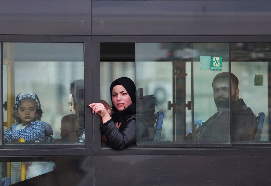 La gente guarda attraverso il finestrino dell’autobus, dopo che i ribelli hanno preso la capitale e cacciato Bashar al-Assad dalla Siria, a Damasco (REUTERS)