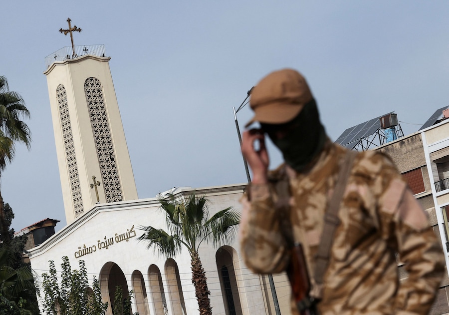 Un combattente ribelle fa la guardia sulla strada di fronte alla chiesa “Signora di Damasco”, dopo che i ribelli hanno preso la capitale e cacciato il presidente siriano Bashar al-Assad, a Damasco, Siria (REUTERS)