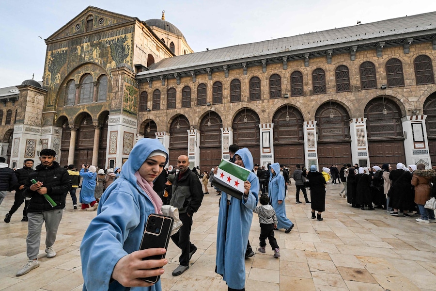 Una donna si filma con il suo smartphone nel cortile della moschea degli Omayyadi dell’VIII secolo a Damasco il 10 dicembre 2024. I ribelli guidati dagli islamisti hanno preso Damasco con un’offensiva lampo l’8 dicembre, estromettendo il presidente Bashar al-Assad e ponendo fine a cinque decenni di governo Baath in Siria (AFP)