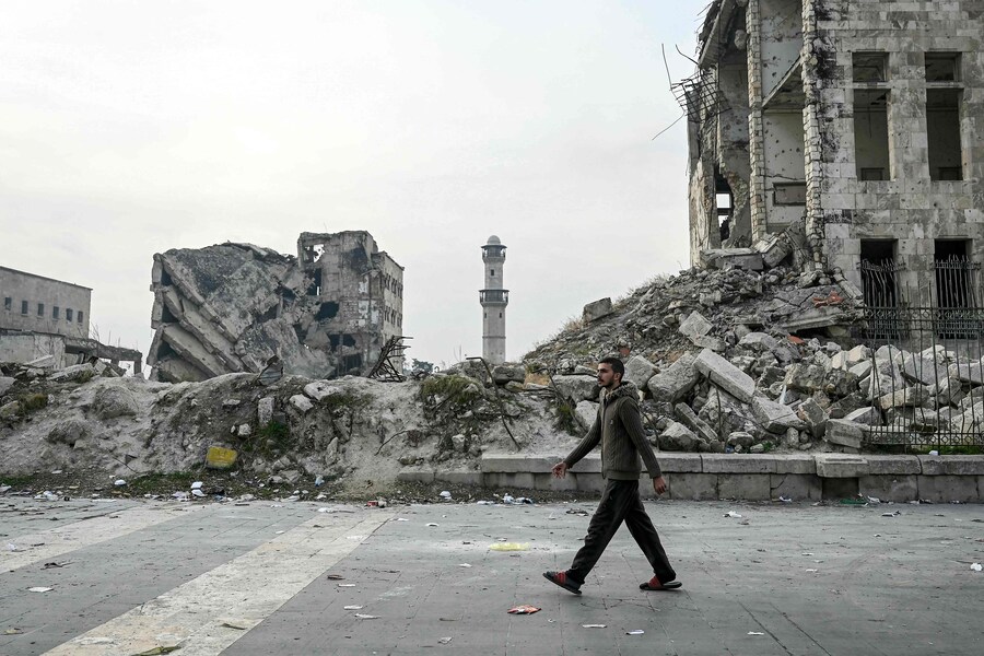 Un uomo cammina tra le macerie di un edificio danneggiato nella Cittadella di Aleppo, nel nord della Siria, l’11 dicembre 2024. I ribelli guidati dagli islamisti hanno preso la capitale siriana Damasco con un’offensiva lampo l’8 dicembre, estromettendo il presidente Bashar al-Assad e ponendo fine a cinque decenni di governo Baath nel paese. (AFP)