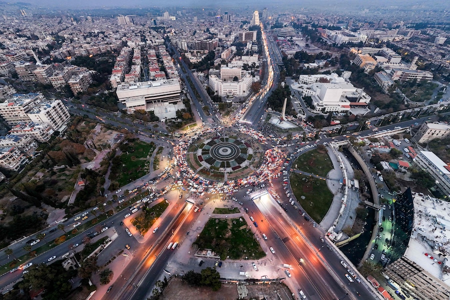 Questa vista aerea mostra il traffico nella piazza centrale degli Omayyadi di Damasco al tramonto (AFP)