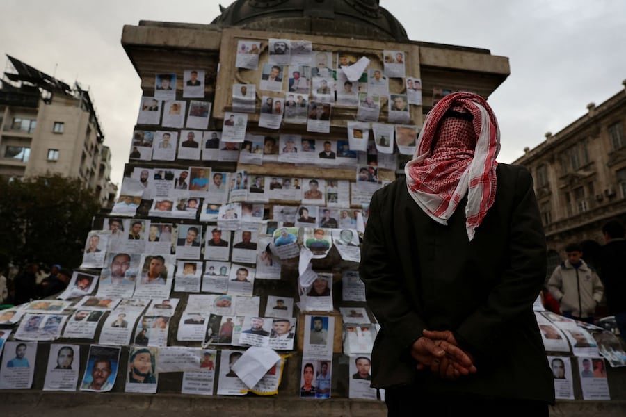 Un uomo guarda le foto di persone scomparse, ritenute prigionieri della prigione di Sednaya, nota come “mattatoio” sotto il governo di Bashar al-Assad. (REUTERS/Yamam Al shaar)