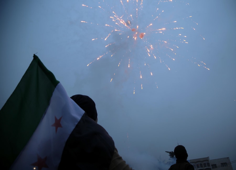 Persone sventolano bandiere dell’opposizione siriana mentre partecipano alla “Festa della Liberazione” per celebrare la cacciata del presidente siriano Bashar Al-Assad. (EPA/BILAL AL HAMMOUD) (EPA)