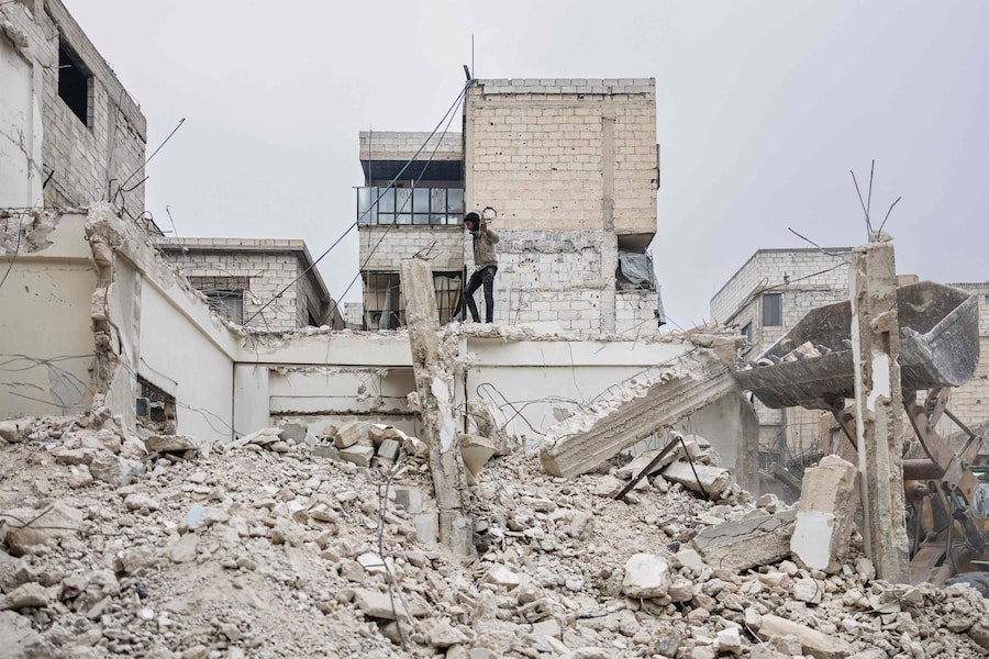 Un giovane cammina tra le macerie di un edificio distrutto in fase di demolizione nella città di Douma. ( Sameer Al-DOUMY / AFP) (AFP)