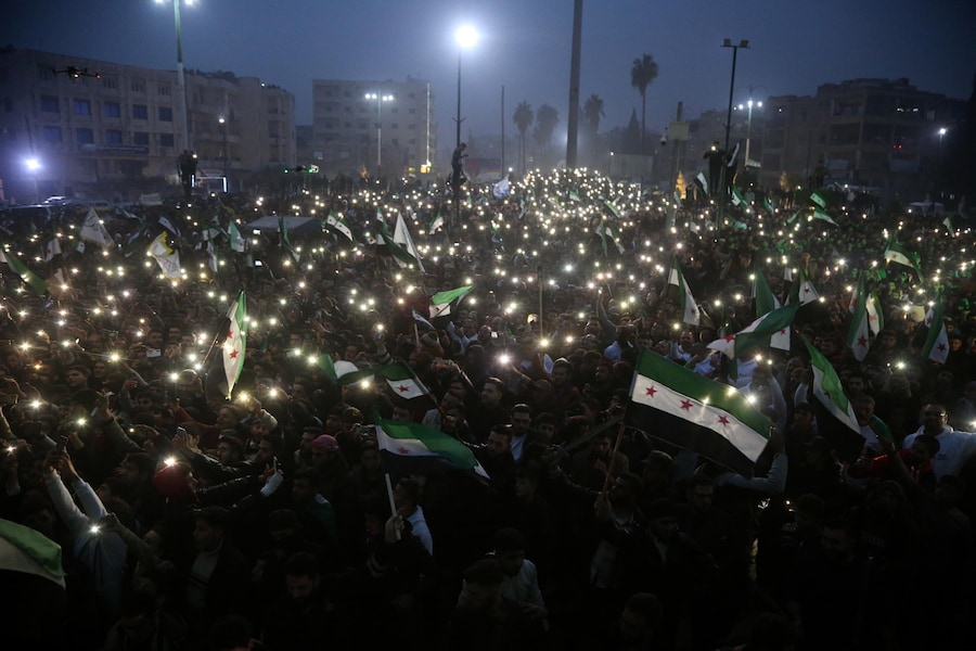 Persone sventolano bandiere dell’opposizione siriana mentre partecipano alla “Festa della Liberazione” per celebrare la cacciata del presidente siriano Bashar Al-Assad. (EPA/BILAL AL HAMMOUD)