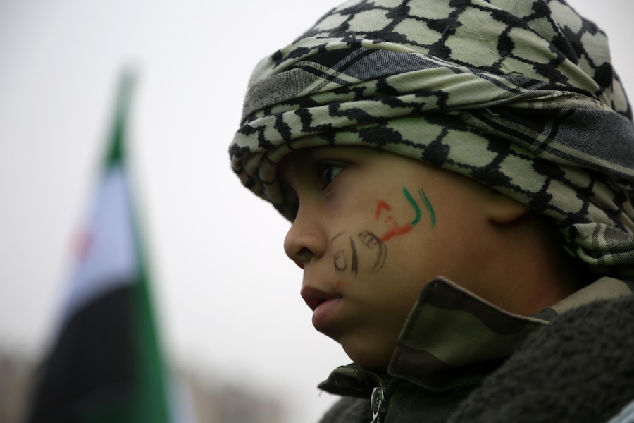 Un bambino con una scritta sul volto con i colori siriani che recita “Rivoluzione” partecipa alla “Festa della Liberazione”. (EPA/BILAL AL HAMMOUD)