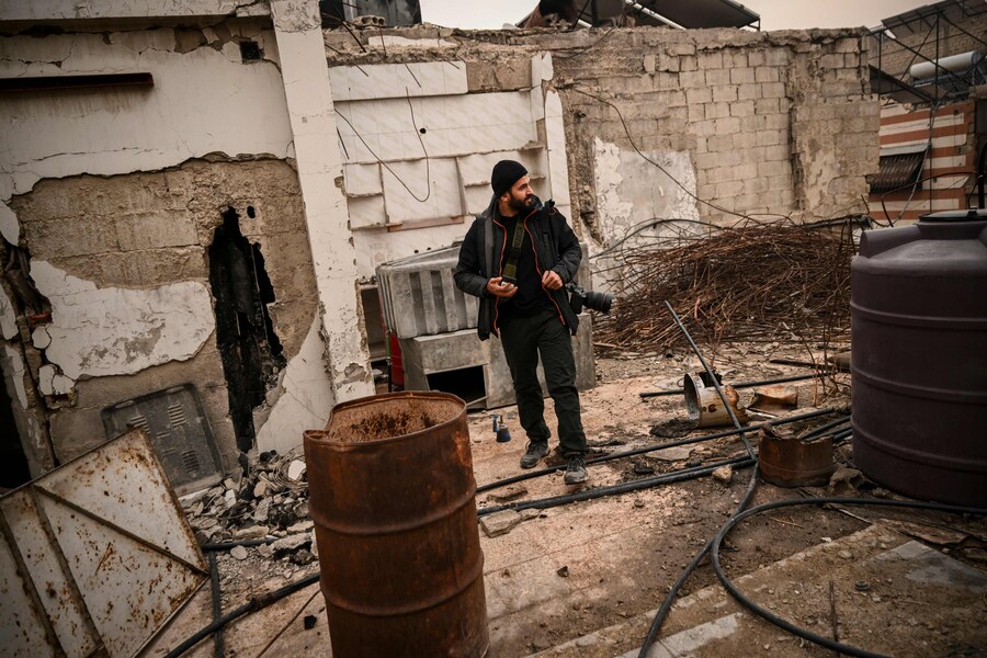 Il fotografo siriano dell’AFP Sameer al-Doumy cammina nel suo vecchio quartiere nella città di Douma. ( Aris MESSINIS / AFP)