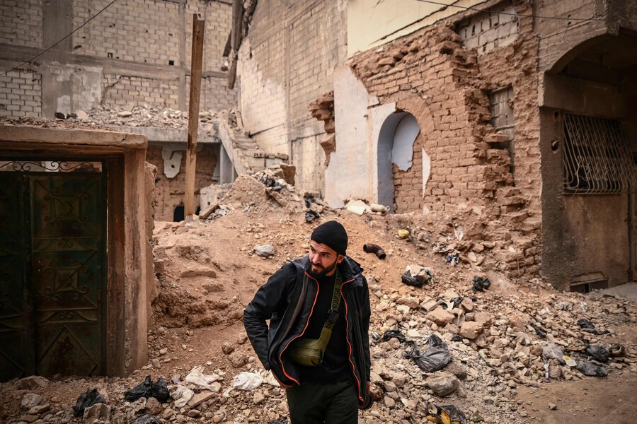 Il fotografo siriano dell’AFP Sameer al-Doumy cammina nel suo vecchio quartiere nella città di Douma. ( Aris MESSINIS / AFP)