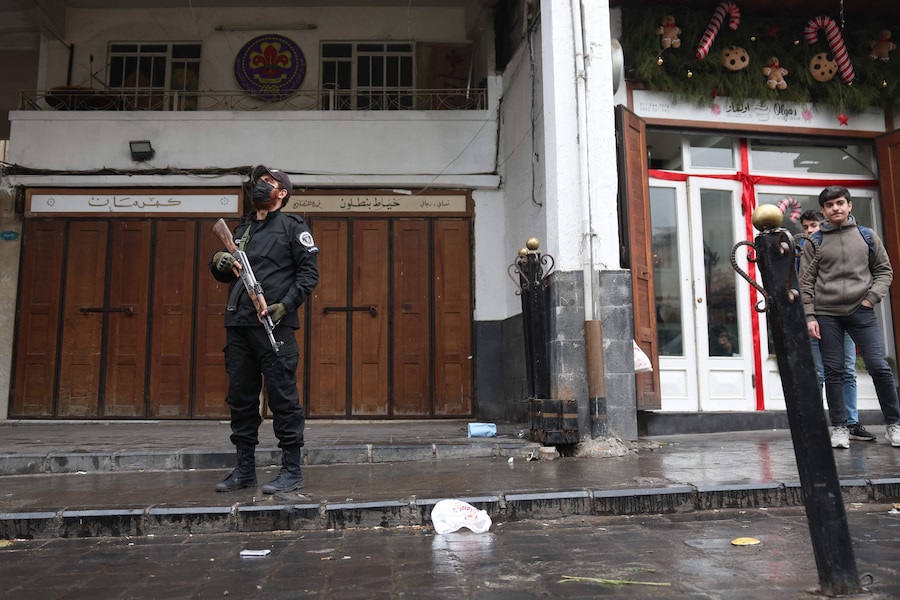 A member of the Syrian security forces, under the guidance of the transitional government, stands guard in a street in the capital Damascus on December 24, 2024. Syria's new leaders announced that they had reached an agreement with the country's rebel groups on their dissolution and integration under the defence ministry. (Photo by OMAR HAJ KADOUR / AFP) (AFP)