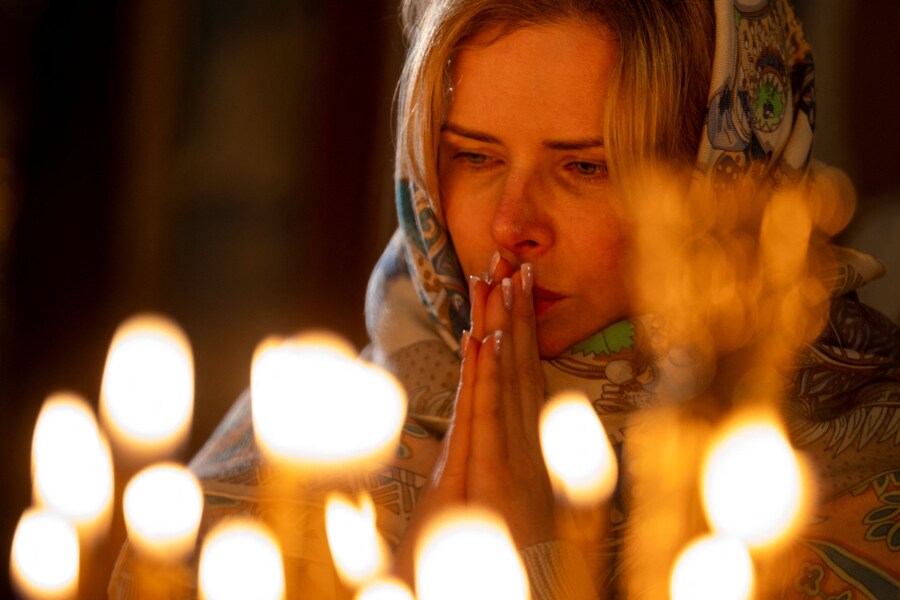 Una donna assiste alla funzione della vigilia di Natale nella Cattedrale di San Michele dalla cupola d’oro. REUTERS/Thomas Peter