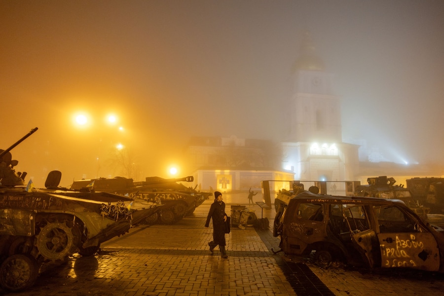 Una donna cammina per strada la vigilia di Natale in una notte di nebbia, in mezzo all’attacco della Russia all’Ucraina. REUTERS/Thomas Peter