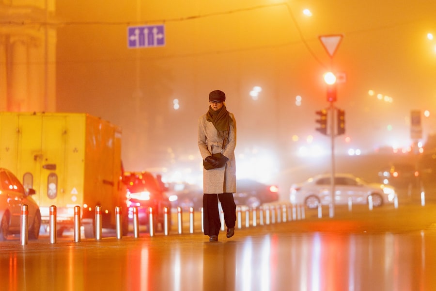 Una donna cammina per strada la vigilia di Natale in una notte di nebbia, in mezzo all’attacco della Russia all’Ucraina . REUTERS/Thomas Peter