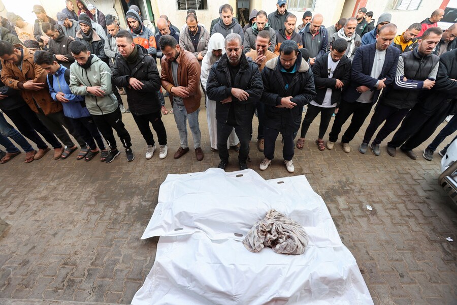 I fedeli recitano le preghiere funebri accanto ai corpi dei palestinesi uccisi da un attacco israeliano, nel corso del conflitto in corso tra Israele e Hamas, presso l’ospedale Al-Aqsa Martyrs, a Deir Al-Balah, nella Striscia di Gaza centrale. (REUTERS/Ramadan Abed)