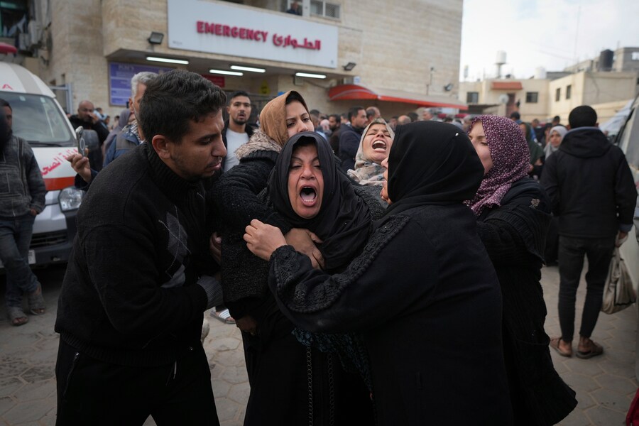 Palestinesi piangono i loro parenti uccisi nei bombardamenti israeliani sulla Striscia di Gaza, presso l’Ospedale dei Martiri di Al-Aqsa a Deir al-Balah. (AP Photo/Abdel Kareem Hana)