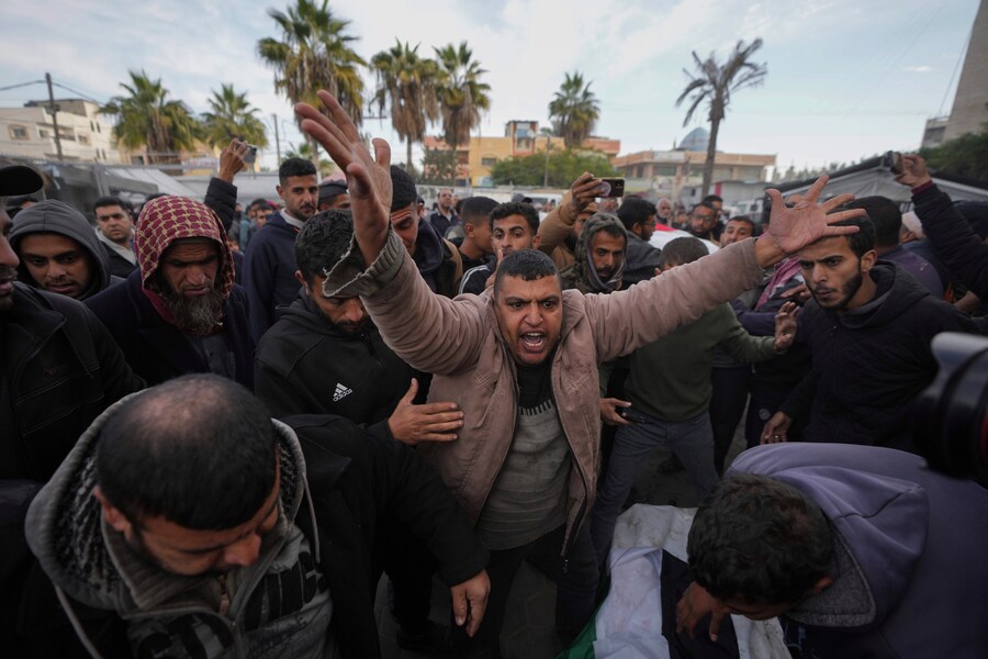 Palestinesi piangono i loro parenti uccisi nei bombardamenti israeliani sulla Striscia di Gaza, presso l’Ospedale dei Martiri di Al-Aqsa a Deir al-Balah. (AP Photo/Abdel Kareem Hana)