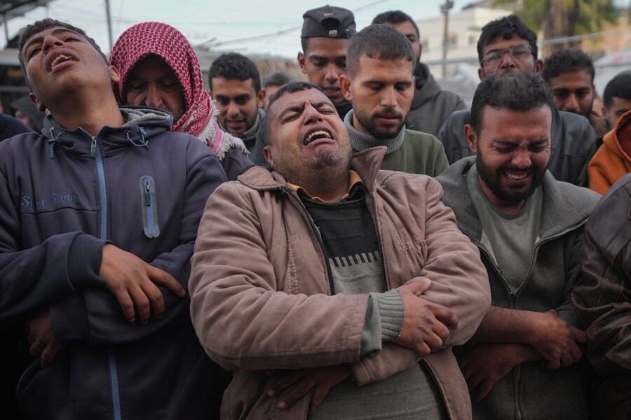 Palestinesi piangono i loro parenti uccisi nei bombardamenti israeliani sulla Striscia di Gaza, presso l’Ospedale dei Martiri di Al-Aqsa a Deir al-Balah. (AP Photo/Abdel Kareem Hana)