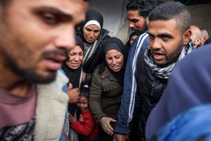 Persone piangono i loro parenti uccisi dai bombardamenti israeliani all’esterno dell’ospedale dei Martiri di Aqsa a Deir el-Balah, nella Striscia di Gaza centrale. (Eyad BABA / AFP)