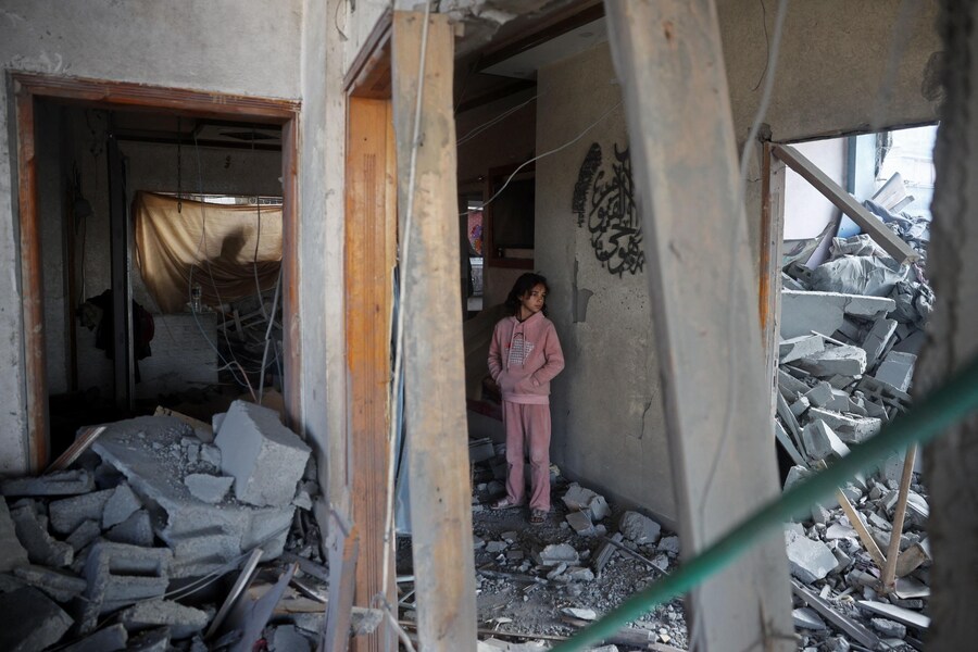 Una ragazza si trova all’interno di un edificio distrutto a seguito di un attacco aereo israeliano sul campo di Bureij per i rifugiati palestinesi nella Striscia di Gaza centrale. (Eyad BABA / AFP)