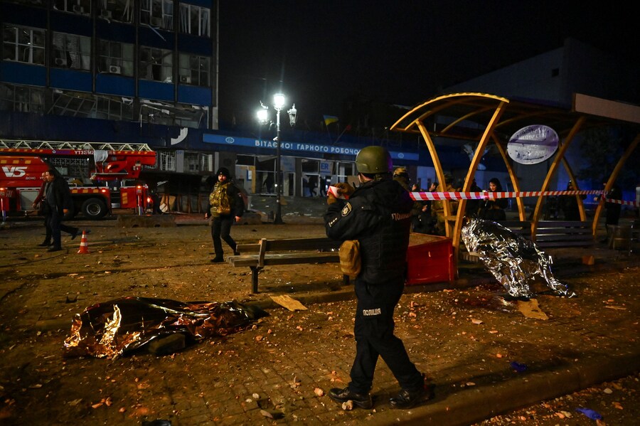 Un agente di polizia srotola un nastro segnaletico attorno a una fermata dei mezzi pubblici dove i residenti sono stati uccisi da attacchi aerei e missilistici russi. (REUTERS/Stringer) (REUTERS)