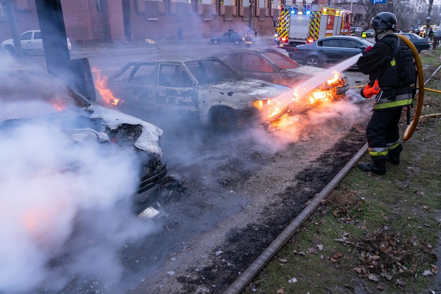 Un pompiere spegne le auto in fiamme. (Foto AFP / Amministrazione militare regionale di Zaporizhia) (AFP)