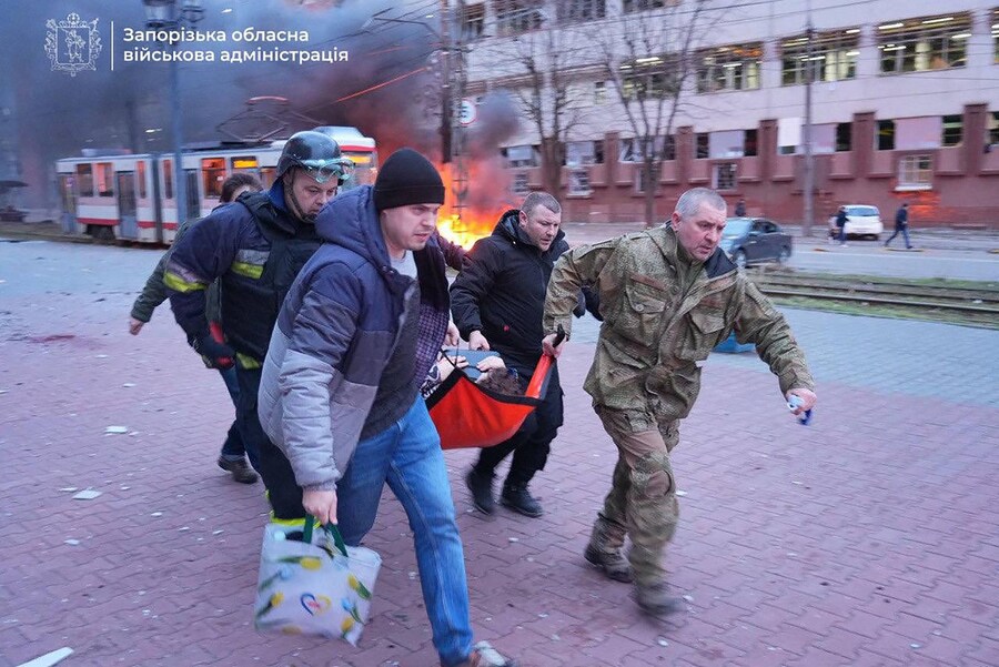 Civili che aiutano il personale di emergenza a trasportare una persona ferita nel sito dell’attacco russo nella città di Zaporizhia. (Foto di Handout / Telegram /@ivan_fedorov_zp / AFP) / FOTO AFP / Canale Telegram del capo dell’Amministrazione militare regionale di Zaporizhia Ivan Fedorov” (AFP)