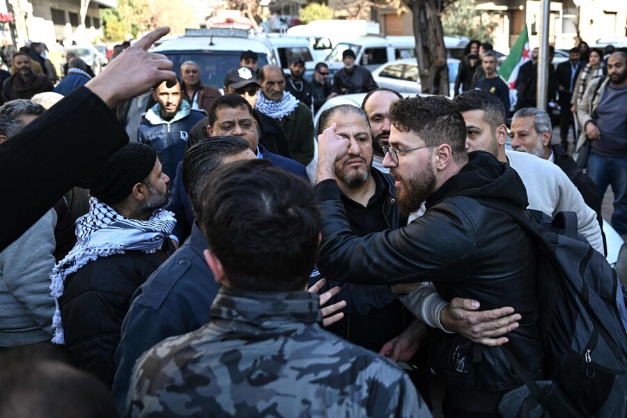 Le forze di sicurezza delle nuove autorità siriane dividono alcune persone radunate per mostrare il loro sostegno all’Autorità Nazionale Palestinese e altre che guidano una contromanifestazione di fronte all’ambasciata palestinese a Damasco. (AFP)