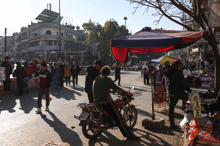 Un uomo guida una moto in un mercato di Homs. (OMAR HAJ KADOUR / AFP)