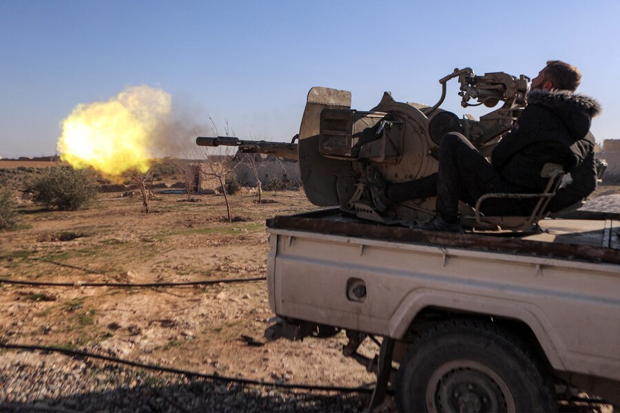 Un combattente della fazione dell’Esercito nazionale siriano sostenuta dalla Turchia spara da una torretta montata sul retro di un pick-up “tecnico” schierato in una posizione vicino alla diga di Tishrin. (AAREF WATAD / AFP)