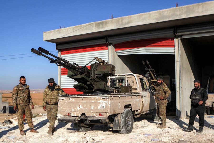 Combattenti della fazione dell’Esercito nazionale siriano sostenuta dalla Turchia si trovano accanto a un pick-up “tecnico” in una postazione vicino alla diga di Tishrin, nei pressi di Manbij. (AAREF WATAD / AFP)
