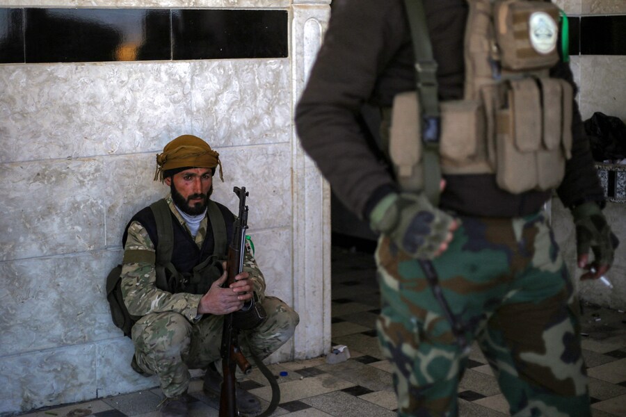 Un combattente della fazione dell’Esercito nazionale siriano sostenuta dalla Turchia siede in una casa vicino alla diga di Tishrin, nei pressi di Manbij. (AAREF WATAD / AFP)