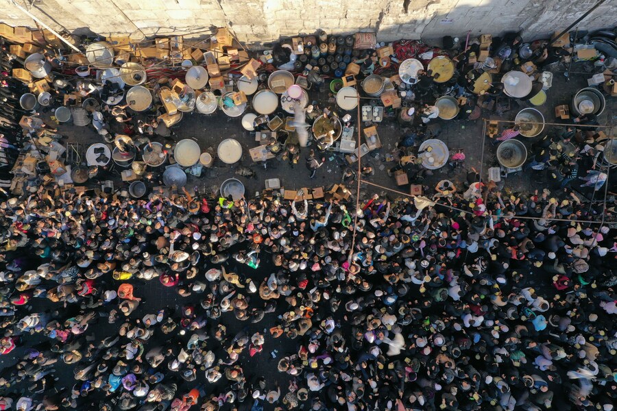 Una folla si raduna fuori dalla Moschea degli Omayyadi durante la distribuzione di pasti gratuiti dopo la preghiera del venerdì a Damasco. (AP Photo/Ghaith Alsayed)