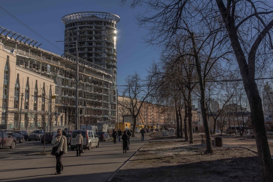 Le persone camminano accanto agli edifici danneggiati in seguito a un recente attacco missilistico russo a Kiev. (Photo by Roman PILIPEY / AFP) (AFP)