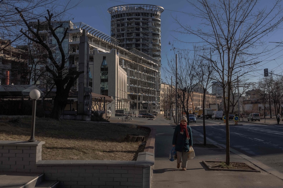 Una donna anziana cammina accanto a edifici danneggiati in seguito a un recente attacco missilistico russo a Kiev. (Photo by Roman PILIPEY / AFP) (AFP)