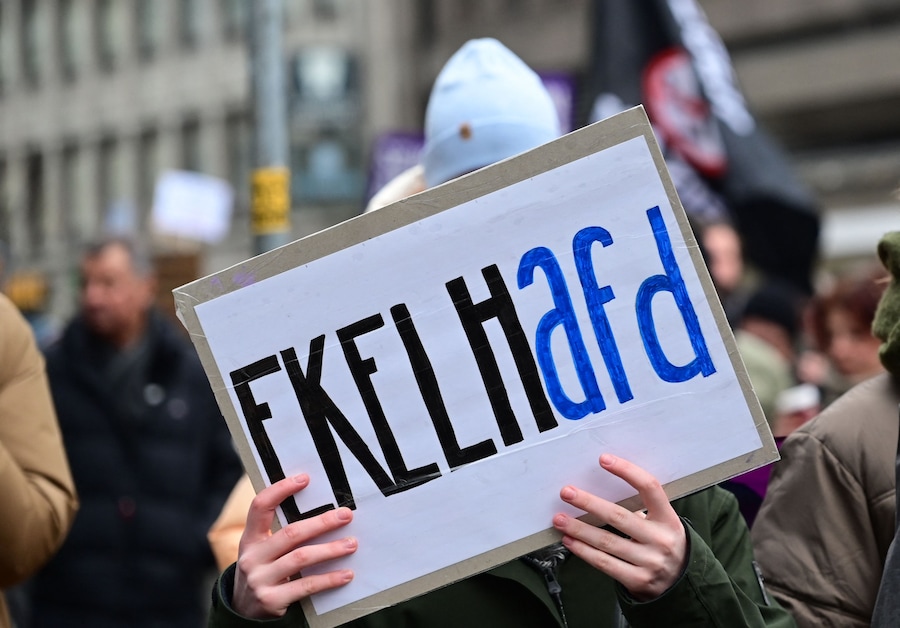 La gente partecipa a una protesta anti-estrema destra a Dortmund. Molti accusano il centrodestra CDU/CSU, attualmente in testa ai sondaggi con circa il 30%, di aver fatto un buco nel muro la scorsa settimana collaborando con l’AfD per ottenere la maggioranza parlamentare per una risoluzione che chiede un freno all’immigrazione. (Photo by INA FASSBENDER / AFP) (AFP)