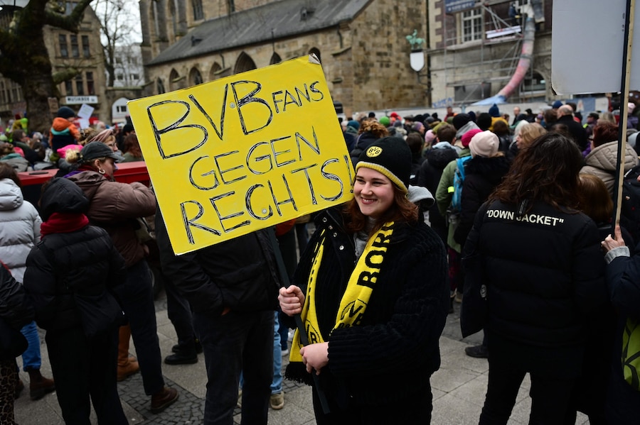 Un tifoso del Borussia Dortmund, squadra di calcio della Bundesliga, mostra un cartello durante una protesta anti-estrema destra a Dortmund. Molti accusano il centrodestra CDU/CSU, attualmente in testa ai sondaggi con circa il 30%, di aver fatto un buco nel muro la scorsa settimana collaborando con l’AfD per ottenere la maggioranza parlamentare per una risoluzione che chiede un freno all’immigrazione. (Photo by INA FASSBENDER / AFP) (AFP)