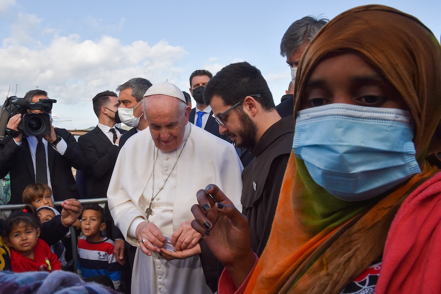 Papa Francesco (al centro) incontra i rifugiati al Centro di Accoglienza e Identificazione (RIC) di Mitilene, sull’isola di Lesbo, il 5 dicembre 2021. (Photo by Andreas SOLARO / AFP) (AFP)