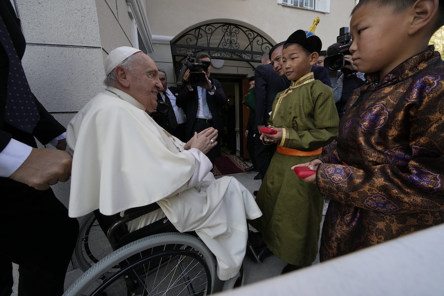 Bambini in abiti tradizionali accolgono Papa Francesco per un incontro con operatori di beneficenza e per l’inaugurazione della Casa della Misericordia a Ulaanbator il 4 settembre 2023. Papa Francesco, nell’ultimo giorno della sua visita diplomatica in Mongolia, si è recato alla periferia della capitale per inaugurare un rifugio e una clinica per senzatetto. La visita alla “Casa della Misericordia”, che accoglierà anche le sopravvissute alla violenza domestica e i loro figli, in una zona povera di Ulaanbator, si adatta alla pratica di lunga data del papa, 86 anni, di andare incontro a coloro che vivono nelle periferie. (Photo by Andrew Medichini / POOL / AFP) (AFP)