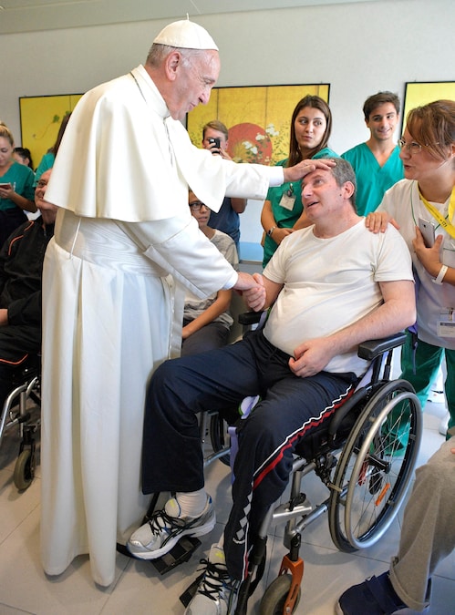 Questa foto di volantino, scattata e diffusa dall’Osservatore Romano il 22 settembre 2017, mostra Papa Francesco mentre saluta un paziente durante la sua visita alla Fondazione Santa Lucia (FSL), un ospedale privato di riabilitazione neurologica e centro di ricerca biomedica senza scopo di lucro, a Roma. (Photo by Handout / OSSERVATORE ROMANO / AFP) (AFP)