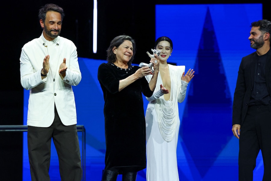 Denise Weinberg, membro del cast, tiene in mano l’Orso d’Argento del Gran Premio della Giuria per “The Blue Trail” mentre il regista Gabriel Mascaro guarda e Rodrigo Santoro applaude durante la cerimonia di premiazione del 75° Festival Internazionale del Cinema di Berlino. (REUTERS)