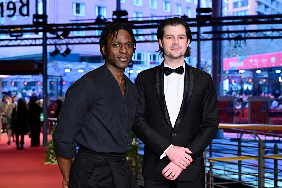 L’attore camerunense Yann Gael (L) e un ospite posano sul tappeto rosso per il gala di chiusura del 75° Festival internazionale del cinema di Berlino. (AFP)