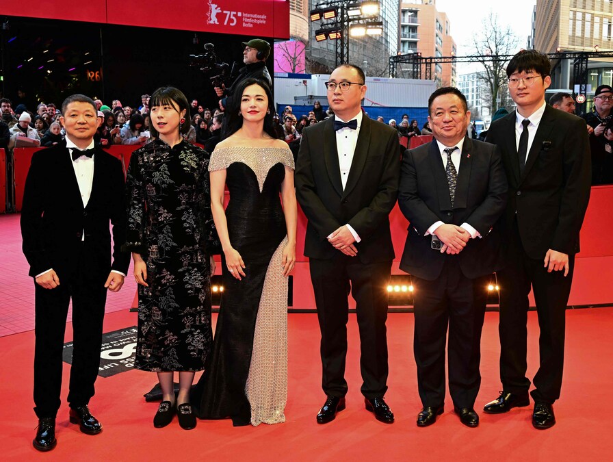 Il produttore cinematografico Zhang Fan (2L), il produttore cinematografico Yao Chen (3L), il regista cinese Huo Meng (3R), il produttore cinematografico Jiang Hao (2R) e altri membri del cast e della troupe posano sul tappeto rosso per il gala di chiusura del 75° Festival internazionale del cinema di Berlino. (AFP)