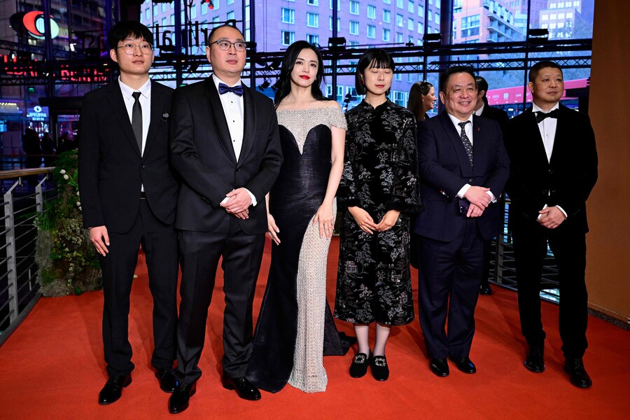 Il produttore cinematografico Zhang Fan (3R), il produttore cinematografico Yao Chen (3L), il regista cinese Huo Meng (2L), il produttore cinematografico Jiang Hao (2R), il direttore della fotografia Cao Yu (R) e un altro membro del cast e della troupe del film “Sheng xi zhi di” (Living the Land) posano sul tappeto rosso per il gala di chiusura del 75° Festival internazionale del cinema di Berlino (AFP)
