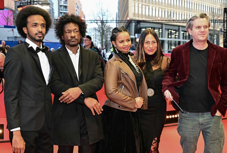 La regista, montatrice e produttrice sudanese Timeea M Ahmed, il regista e direttore della fotografia sudanese Ibrahim Snoopy, la scrittrice e regista sudanese Rawia Alhag a guest e il regista britannico Phil Cox posano sul tappeto rosso per il gala di chiusura del 75° Festival internazionale del cinema di Berlino. (AFP)